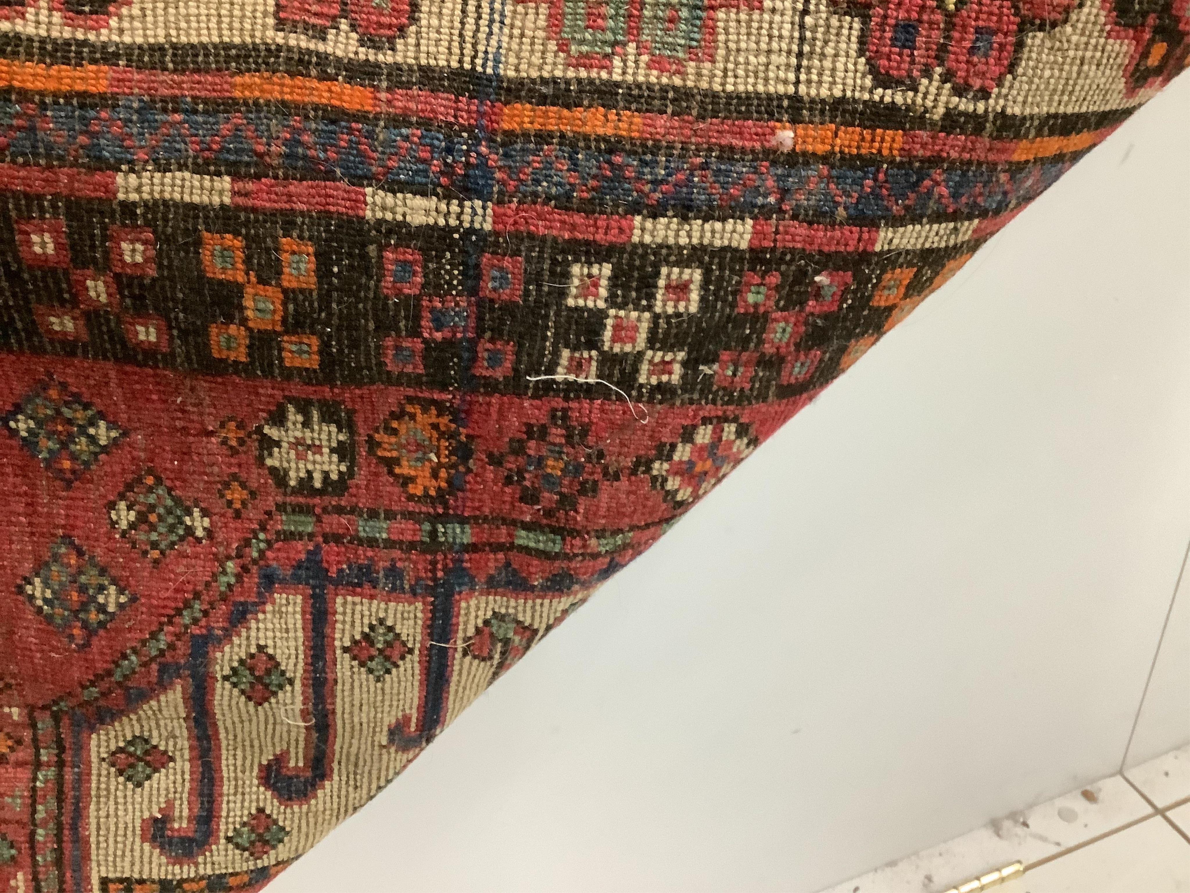 A Caucasian red ground rug, 265 x 130cm. Condition - faded with some wear at the margins